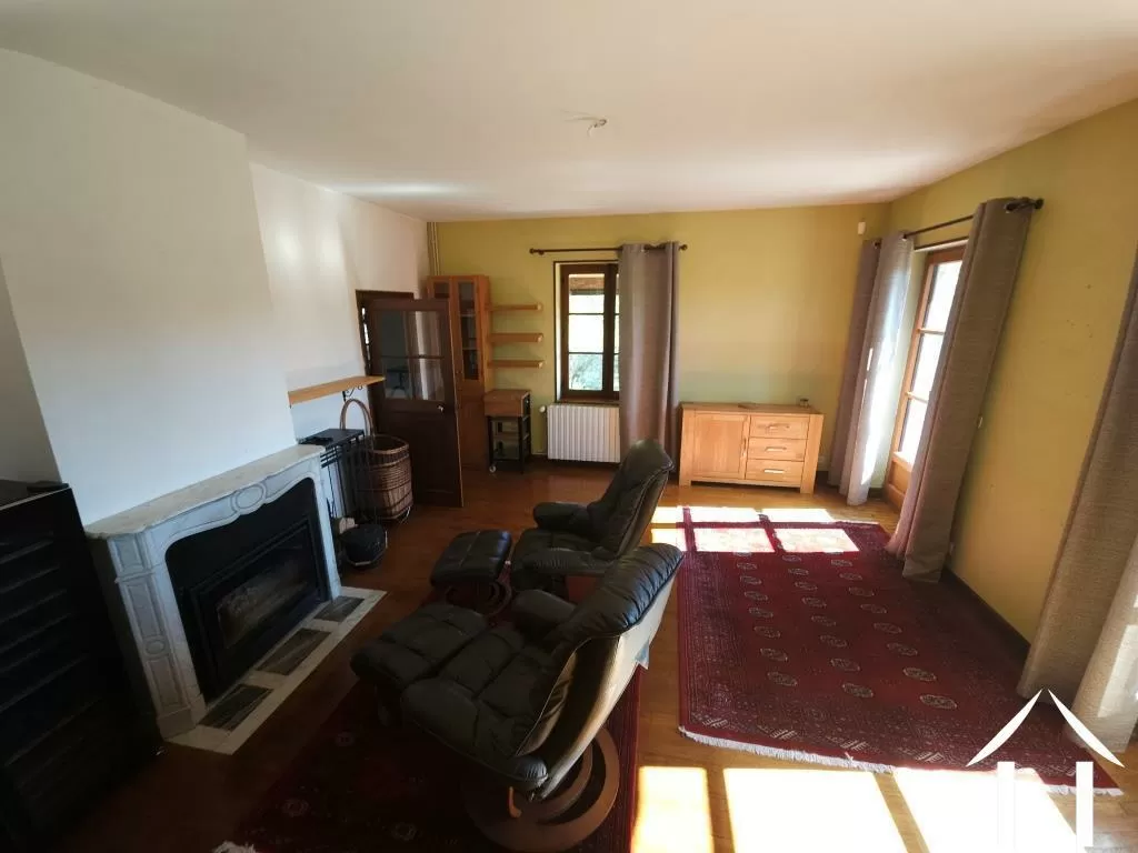 Wohnzimmer mit Kamin und Zugang zur Balkonterrasse