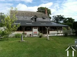 A LARGE HOUSE WITH OUTBUILDINGS AND PADDOCK FOR HORSES.