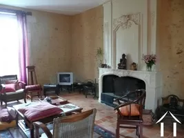 Shows the living room and its very grand fireplace