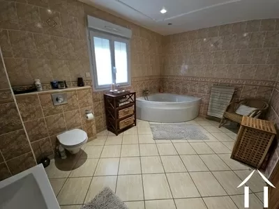 Badezimmer mit Eckbadewanne, Dusche, Waschbecken und Toilette