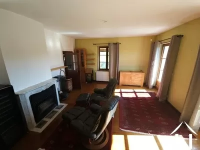 Wohnzimmer mit Kamin und Zugang zur Balkonterrasse